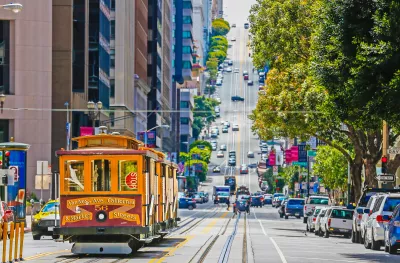 A tram cable car in a busy San Francisco street 